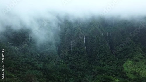Cinematic Aerial of Clouds and Waterfalls After Heavy Rainfall at Bottom of Haiku Stairs Known as Stairway To Heaven on Oahu Island, Hawaii photo