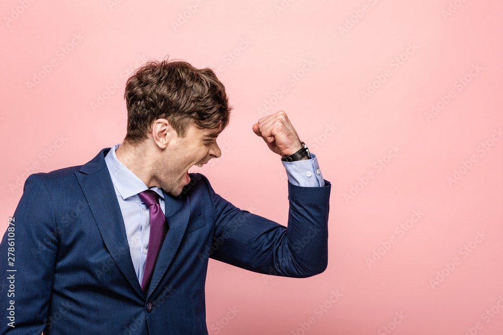 angry businessman showing fist and screaming on pink background angry businessman showing fist and screaming on pink background