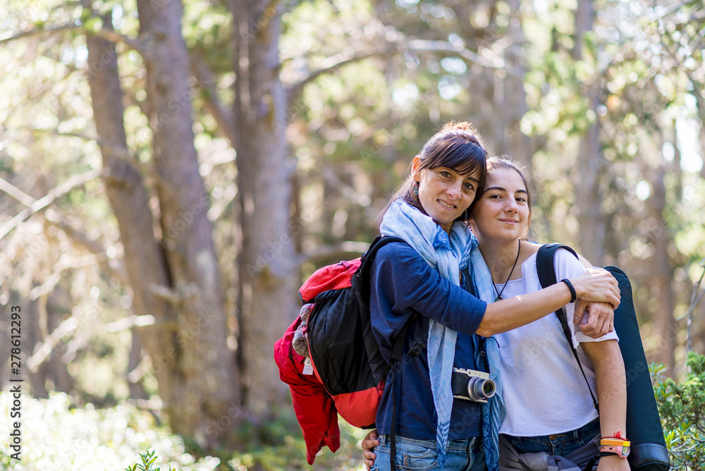 © Cavan Images - Mom hugging her daughter in forest clearing © Cavan Images - Mom hugging her daughter in forest clearing