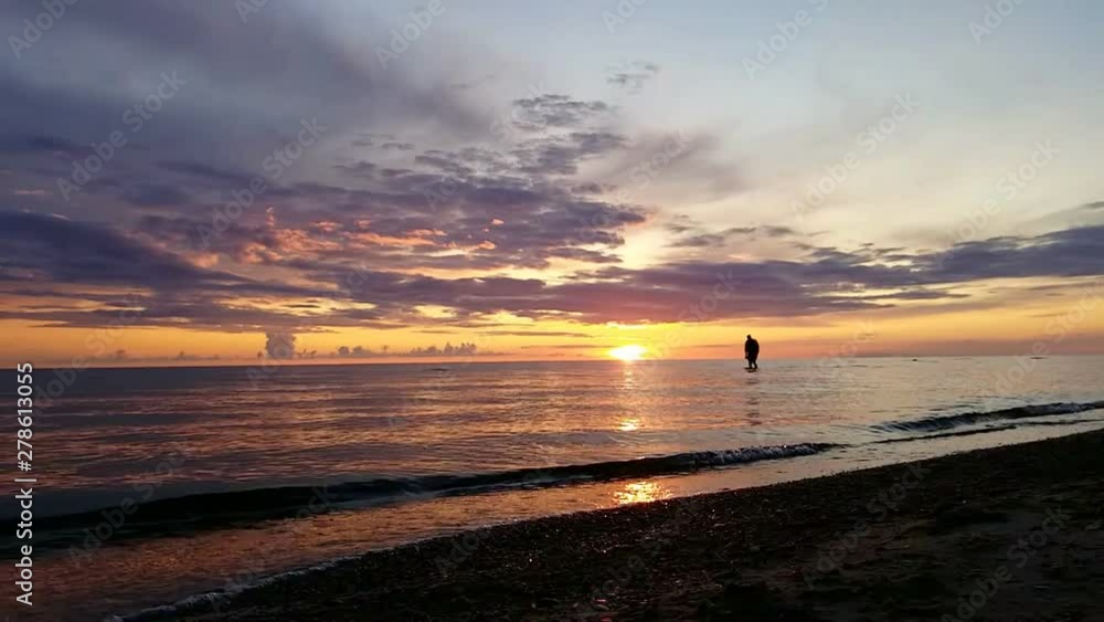 On the reflection of the sun in the Baltic sea, silhouettes of people are visible, during a magnificent color sunset reflecting in the water. No sound. On the reflection of the sun in the Baltic sea, silhouettes of people are visible, during a magnificent color sunset reflecting in the water. No sound.