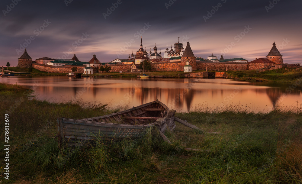 Solovki Or Solovetsky Islands,The Largest Archipelago Of White Sea. Classic View With Old Wooden Russian Boat On The Spaso-Preobrazhensky Solovetsky Monastery At High Tide And Windy Weather.