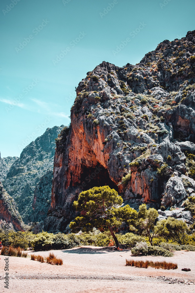 Red rock stone of the wild mountain cliff and natural caves on a right sunny day is a perfect travel spot. Sa Calobra, Torrent de Pareis, Serra de Tramuntana, Mallorca, Spain , Balearic Islands