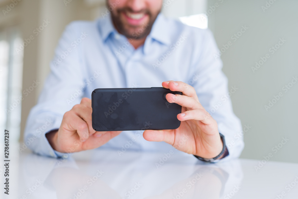 Close up of man hands using smartphone and smiling Close up of man hands using smartphone and smiling