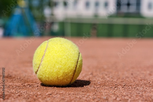 close-up yellow tennis ball on clay court in sport academy for practice of tennis