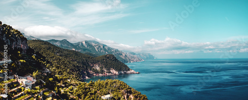 The wild north mountain coastline with clouds hanging in the tops and ocean panorama views. Estellencs, Banyalbufar, Serra de Tramuntana, Mallorca, Spain , Balearic Islands photo