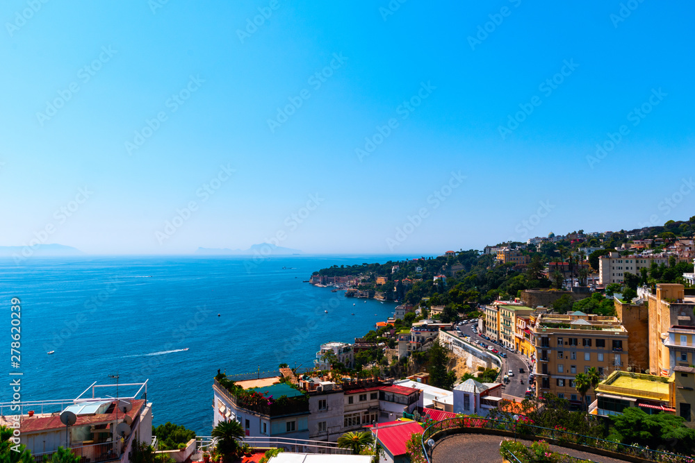 View of the coast of Naples with clear blue sky. Houses on the shore of the Gulf of Naples. Italy, Europe.