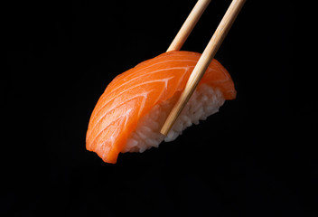 Gordijnen Sushi bar Nigiri met zalm tussen stokjes  © KatrinaEra