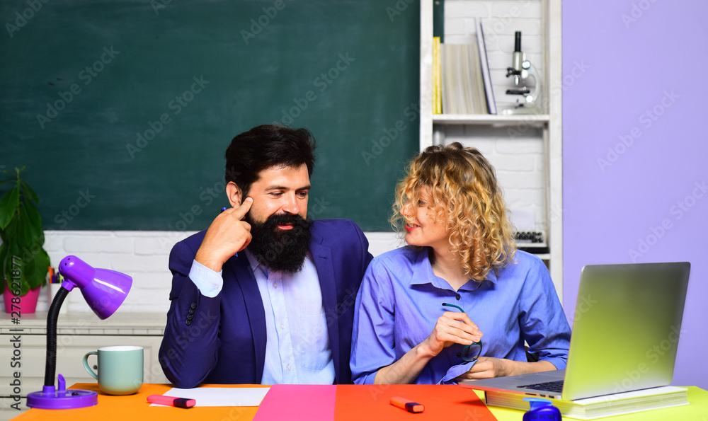 Students couple preparing for test or exam. School students. Two creative happy smiling students in auditorium. Happy casual girl student with bearded hipster teacher. University students at college. Students couple preparing for test or exam. School students. Two creative happy smiling students in auditorium. Happy casual girl student with bearded hipster teacher. University students at college.