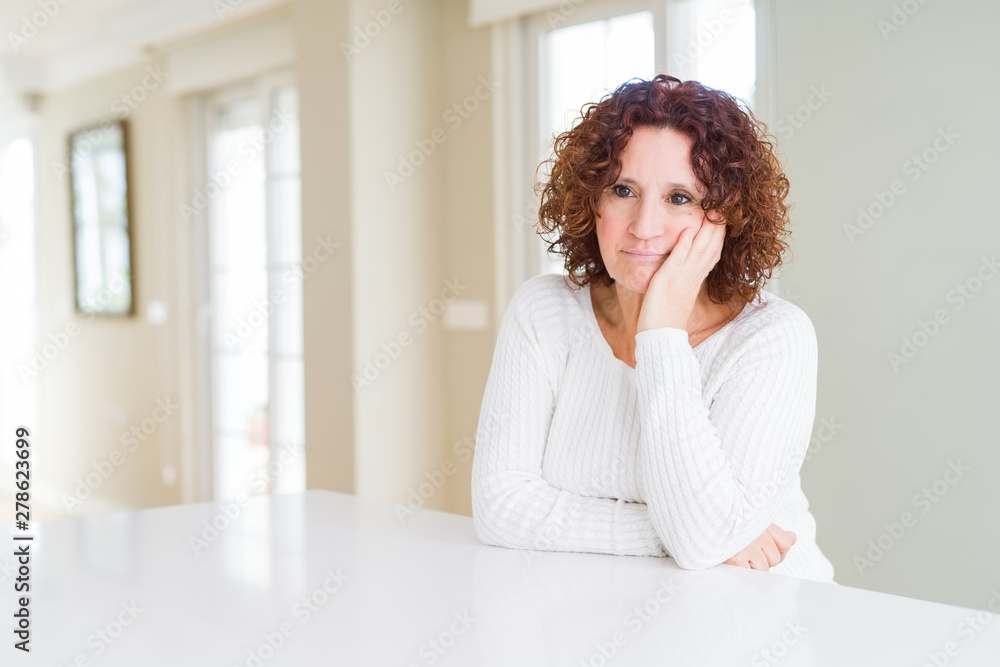 Beautiful senior woman wearing white sweater at home thinking looking tired and bored with depression problems with crossed arms. Beautiful senior woman wearing white sweater at home thinking looking tired and bored with depression problems with crossed arms.