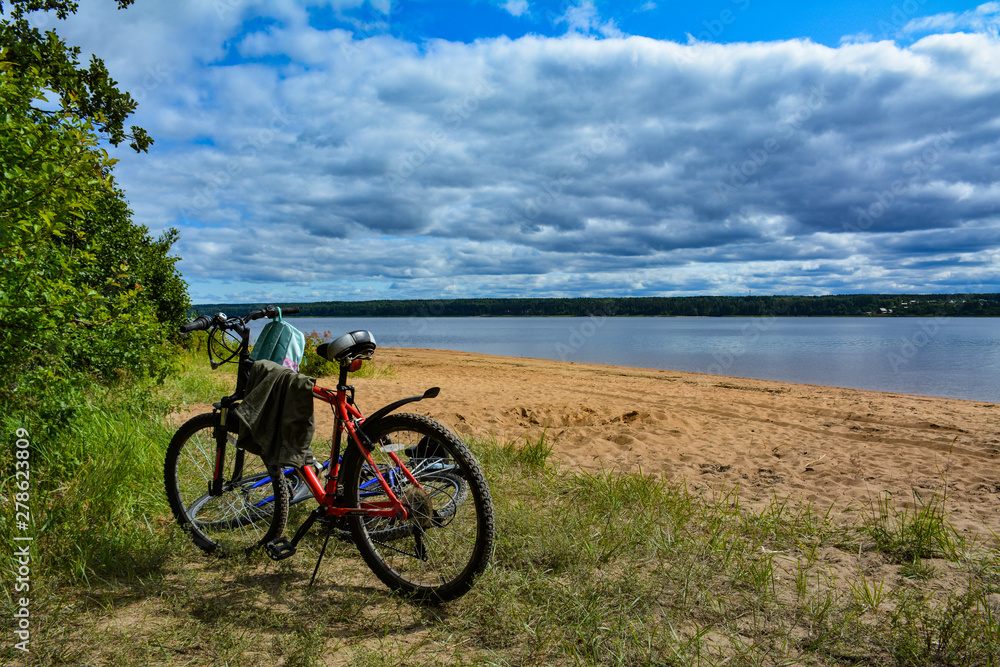 Fototapeta premium Two bicycles on the shore of a large lake