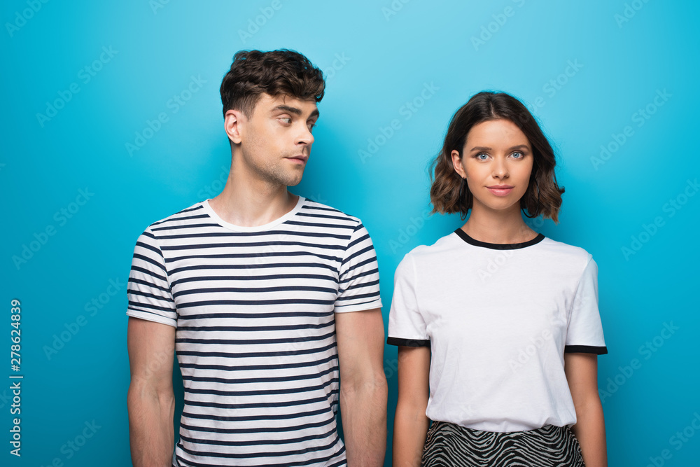 pensive man looking at thoughtful girlfriend on blue background pensive man looking at thoughtful girlfriend on blue background
