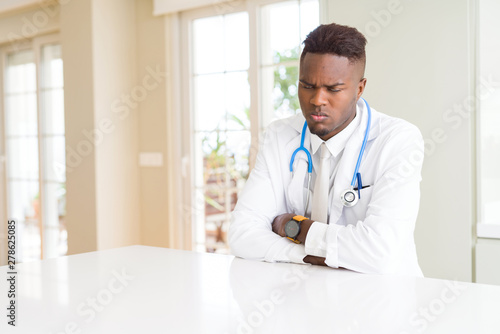 African american doctor man at the clinic skeptic and nervous, disapproving expression on face with crossed arms. Negative person.