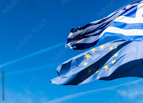 Flags of Greece and European Union on blue sky background, politics of Europe photo