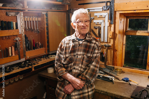 Portrait of amateur senior carpenter, taking pride in his workshop
