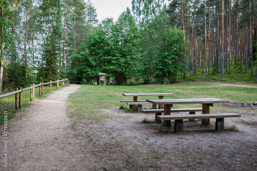 Picnic place in forest with tables and benches on a walking path next to Sietiniezis rock. Gauja National Park. Latvia. Baltic.