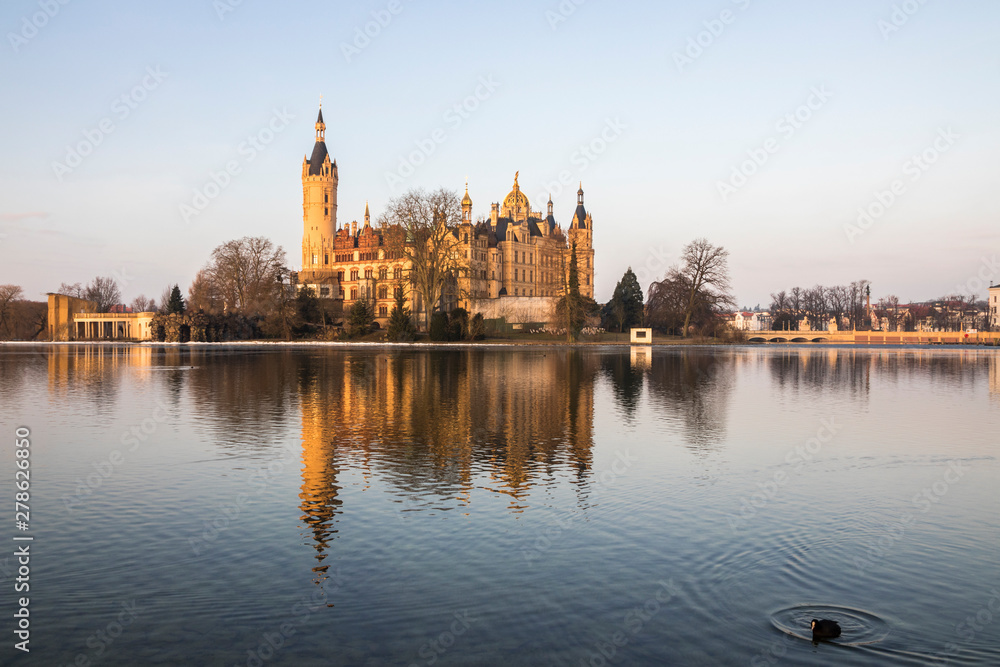 Dawn at Schwerin Palace (Schweriner Schloss), reflected in the water of Schweriner See lake. World Heritage Site in Mecklenburg-Vorpommern, Germany Dawn at Schwerin Palace (Schweriner Schloss), reflected in the water of Schweriner See lake. World Heritage Site in Mecklenburg-Vorpommern, Germany