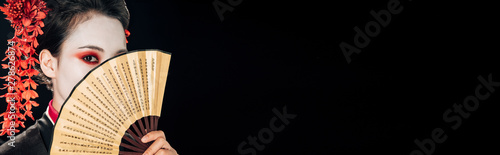Quadro su tela geisha in black kimono with red flowers in hair holding traditional asian hand f