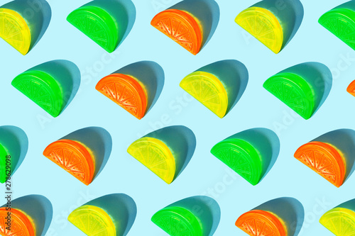 Creative pattern of colorful citrus slices like ice for cocktail on pastel blue background. Pop art minimal flat lay style design, summer drink creative concept. Top view, flatlay. Copy space.