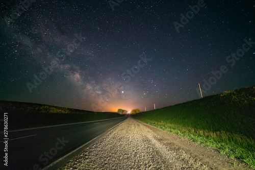 Road, under the night starry sky. Milky Way, over the highway
