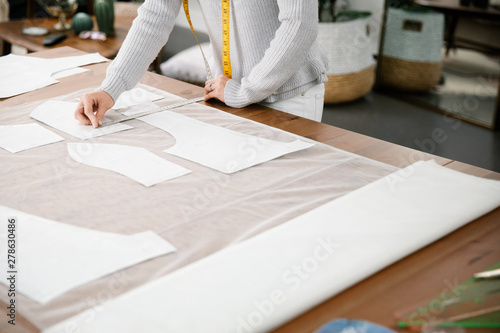 Close up of designer measuring pattern on fabric