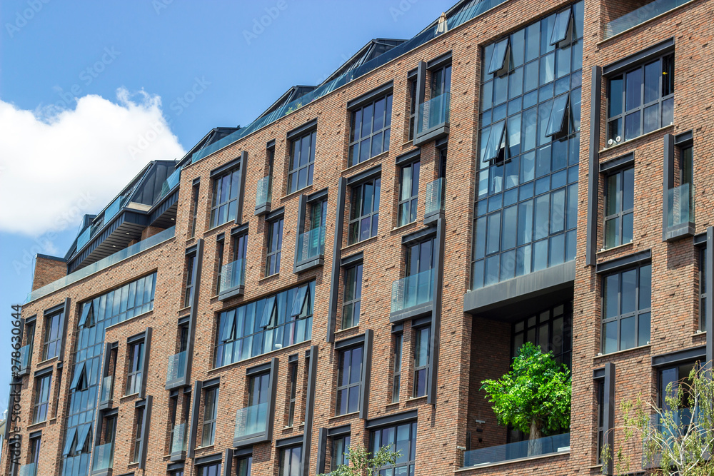 Naklejka premium Side shoot of brick and open glazing facade office building