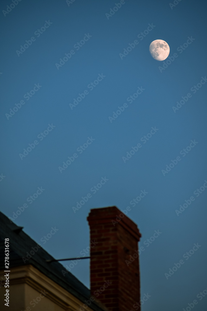 Chimney and roof unfocused, with the moon in the background. Concept of home and night. Chimney and roof unfocused, with the moon in the background. Concept of home and night.