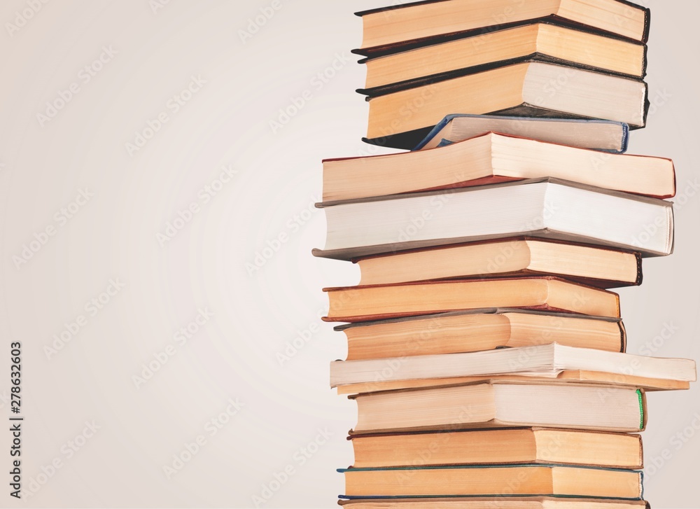 Collection of old books vertical stack on beige background Collection of old books vertical stack on beige background