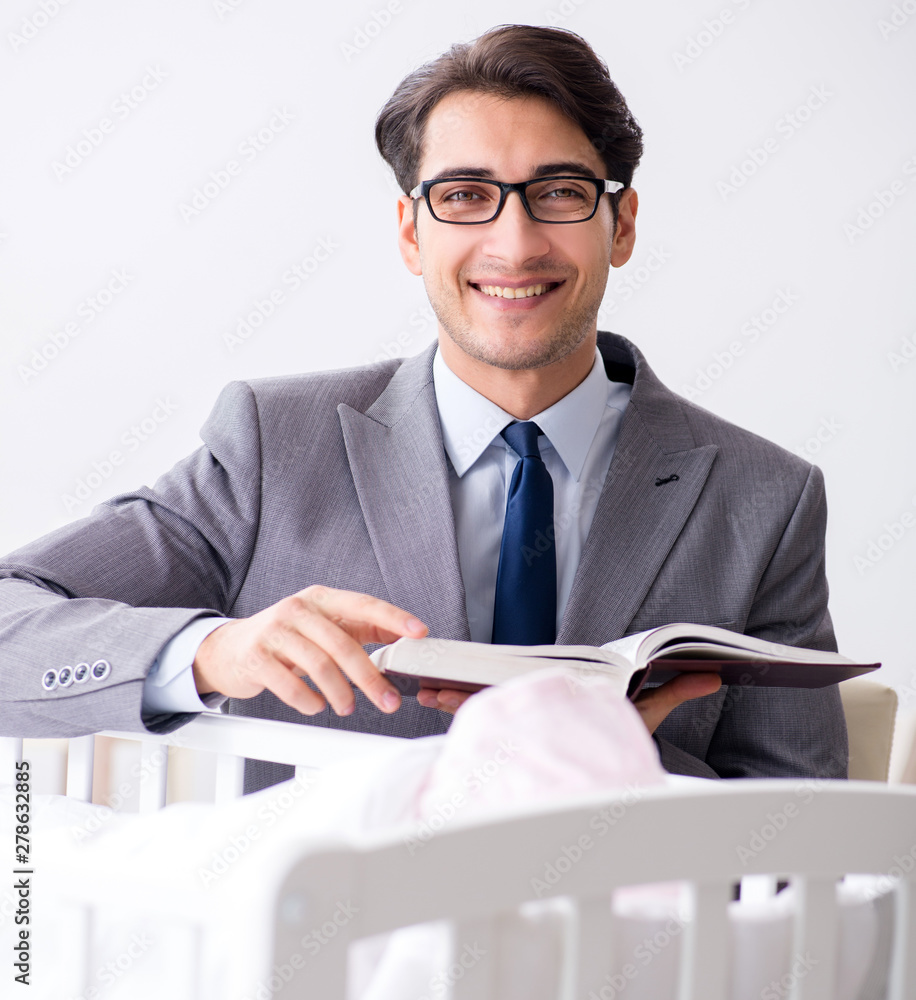 Young businessman trying to work from home caring after newborn Young businessman trying to work from home caring after newborn