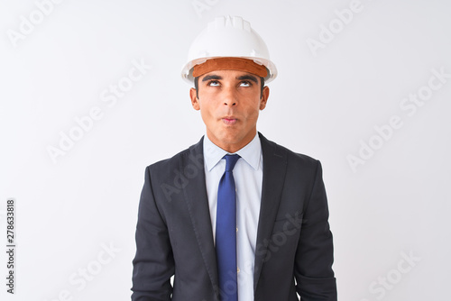Young handsome architect man wearing suit and helmet over isolated white background making fish face with lips, crazy and comical gesture. Funny expression. © Krakenimages.com
