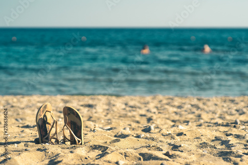 summer background with flip flops on a sandy beach
