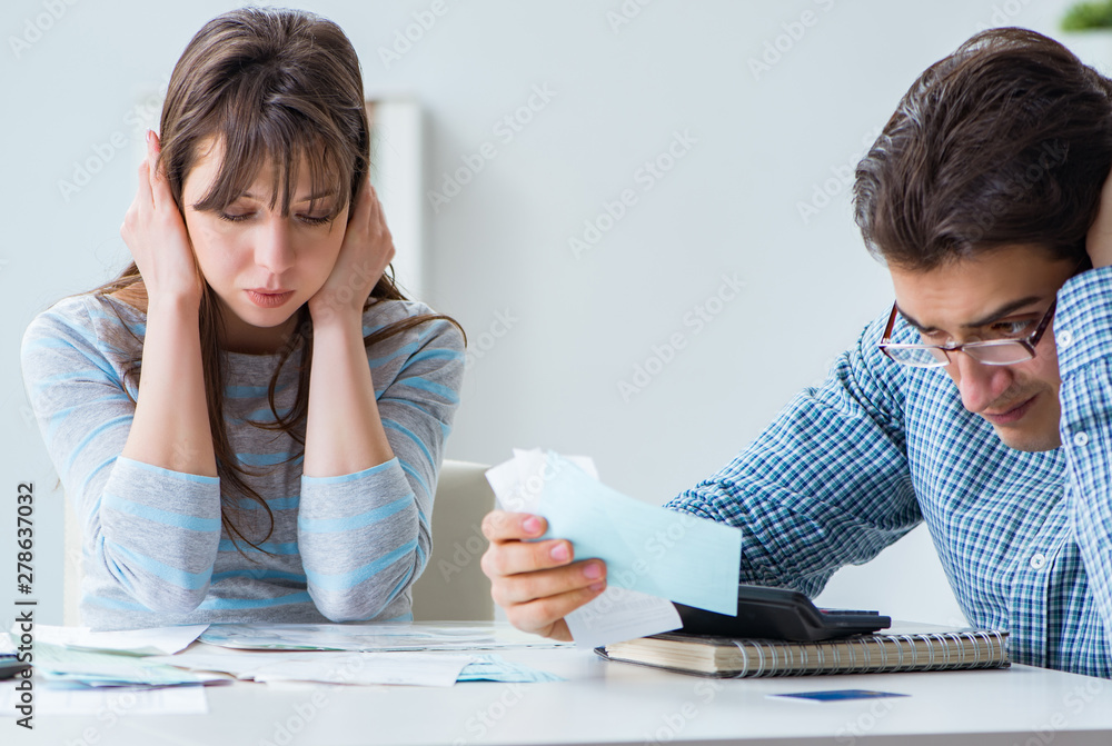 Young couple looking at family finance papers Young couple looking at family finance papers