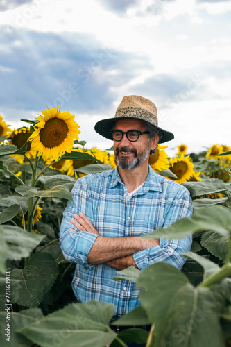 portrait of senior an with hat in sunflower field