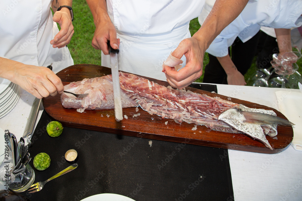 man hand in restaurant outdoors party preparing fish fillets salmon meat