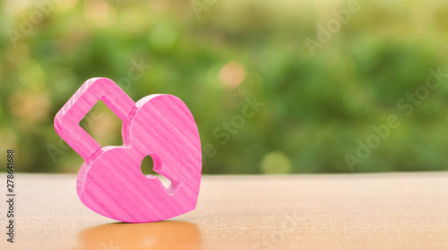 A pink padlock in shape of a heart. Heart health. The secret of relationships and the rules of a strong family. Strong love affair. Secrets, rumors and gossip. The concept of female intimate health.