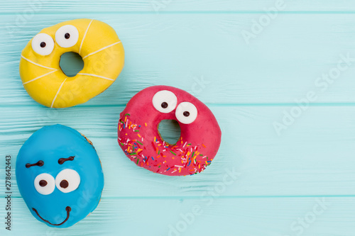 Cuadro en lienzo Three funny donuts on pastel background