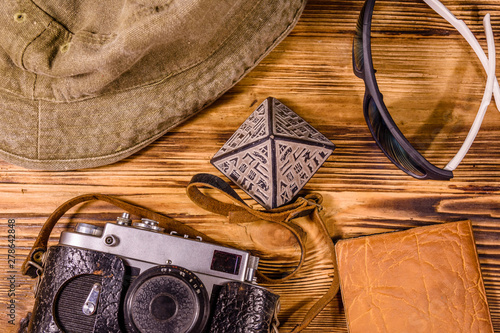 Hipster hat, vintage camera, sunglasses, souvenir pyramid and passport on a wooden background. Travel to Egypt. Top view