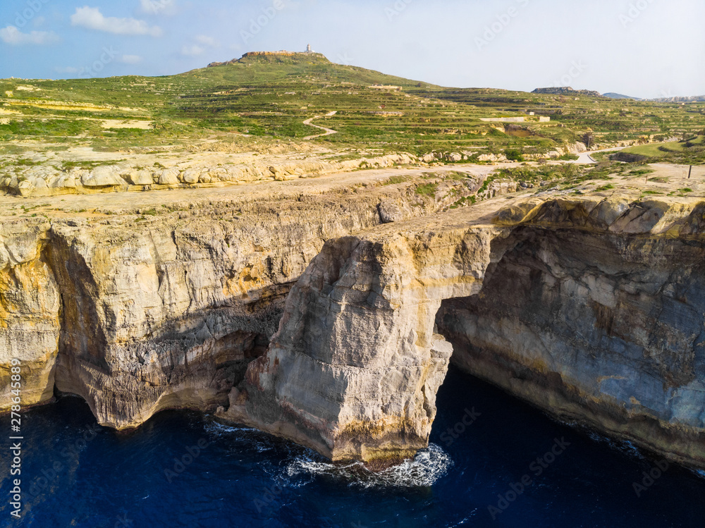 Aerial view of green Gozo island. Wied il-Mielah. Natural arch, lighthouse. Malta Aerial view of green Gozo island. Wied il-Mielah. Natural arch, lighthouse. Malta