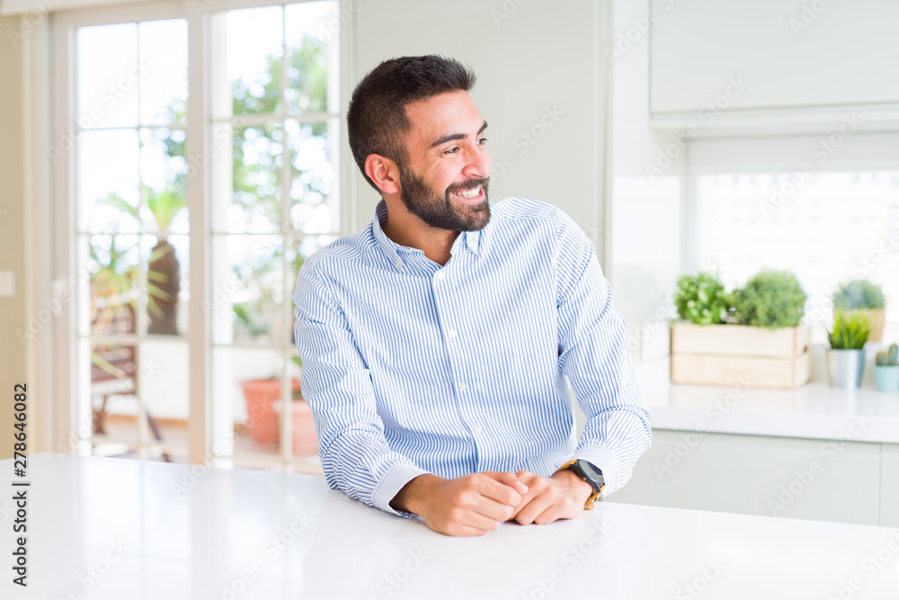 Handsome hispanic business man looking away to side with smile on face, natural expression. Laughing confident.