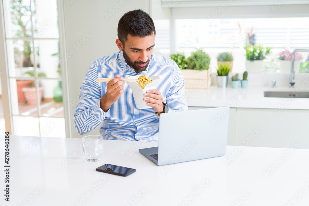 Business man eating asian food from delivery while working using computer laptop at the office Business man eating asian food from delivery while working using computer laptop at the office