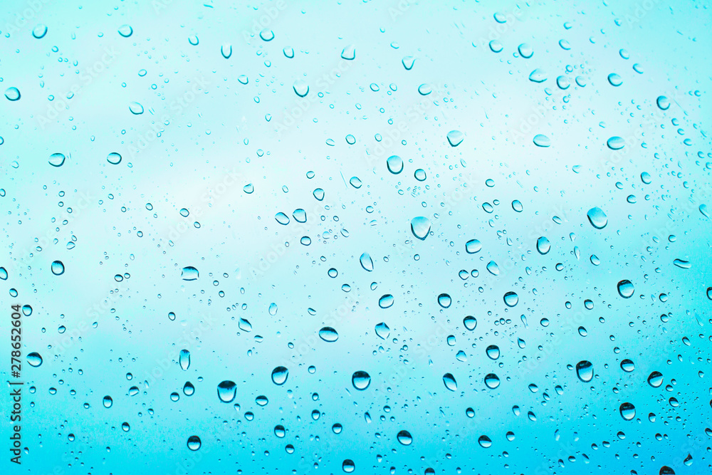of rain standing on a glass. water droplets on glass with blue background