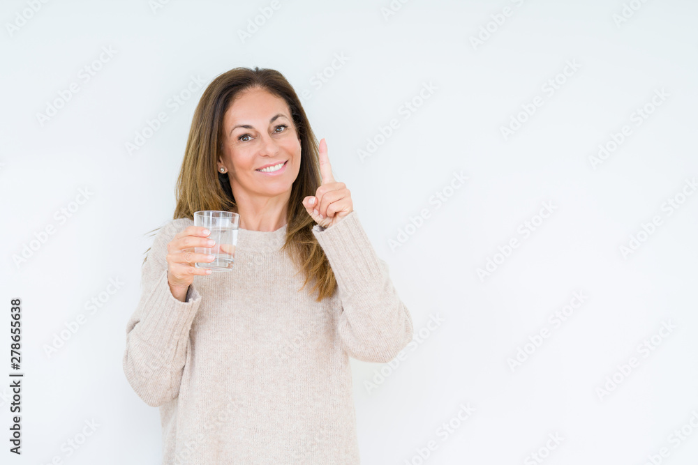 Middle age woman drinking glass of water isolated background surprised with an idea or question pointing finger with happy face, number one Middle age woman drinking glass of water isolated background surprised with an idea or question pointing finger with happy face, number one