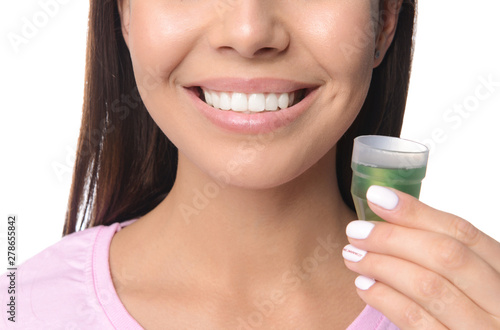 Woman with oral rinse on white background, closeup. Dental hygiene concept