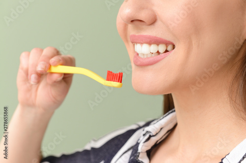 Woman with toothbrush on color background  closeup. Concept of dental hygiene
