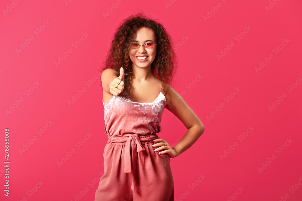 Beautiful young woman showing thumb-up gesture on color background Beautiful young woman showing thumb-up gesture on color background