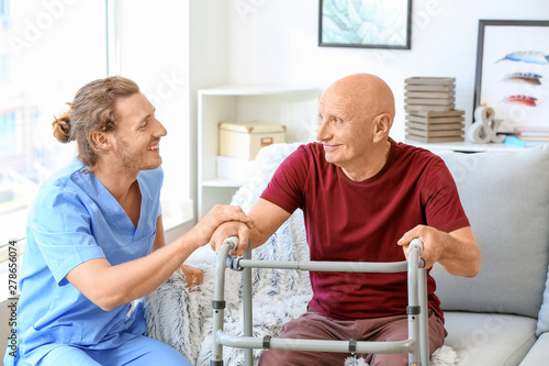 Obraz na plátně Elderly man with caregiver in nursing home
