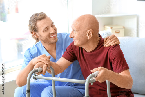 Elderly man with caregiver ...