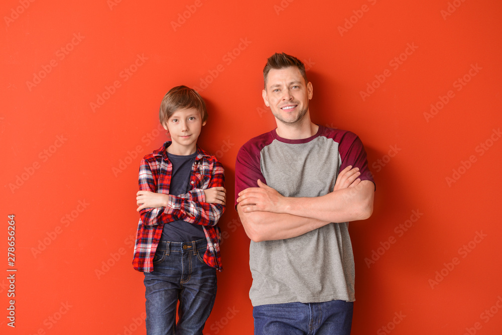 Obraz premium Portrait of father and son on color background