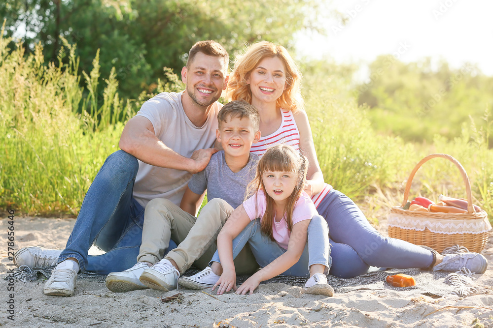 Fototapeta premium Happy family on summer picnic near river