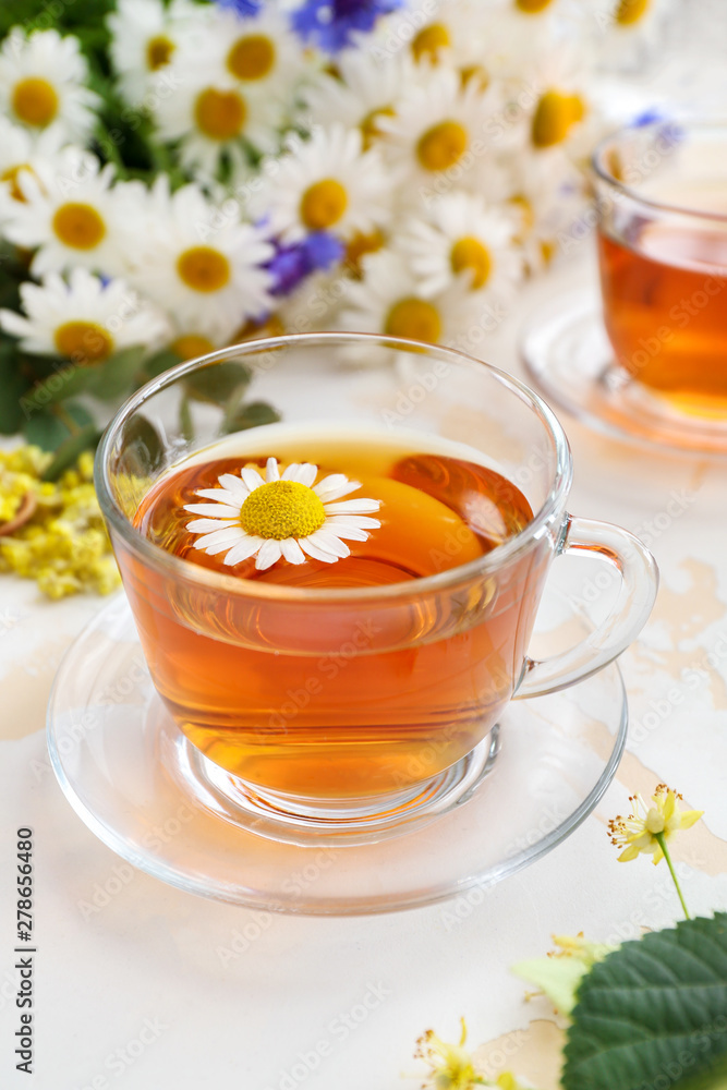 Cup of tasty chamomile tea on light table Cup of tasty chamomile tea on light table