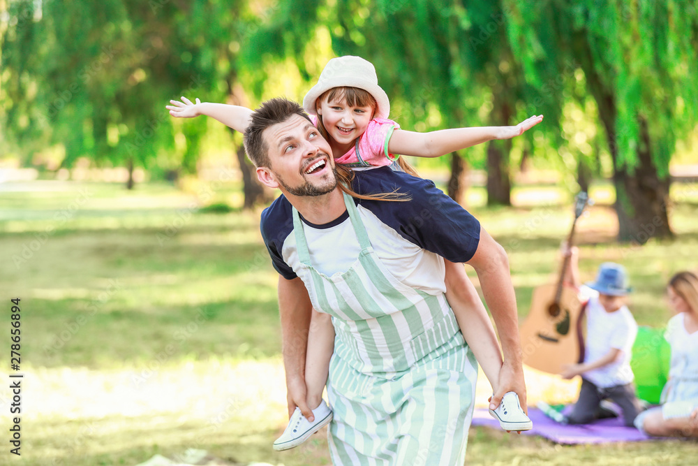Obraz premium Little girl with her father having fun in park on summer day